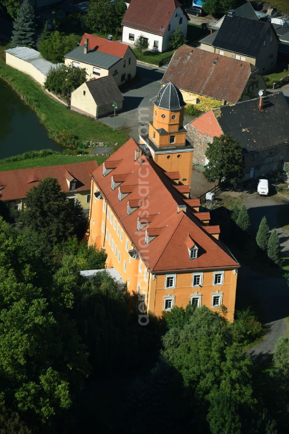 Aerial image Kühnitzsch - Castle of Schloss Kuehnitzsch in Kuehnitzsch in the state of Saxony. The former water castle is located on a small pond with its yellow front and tower