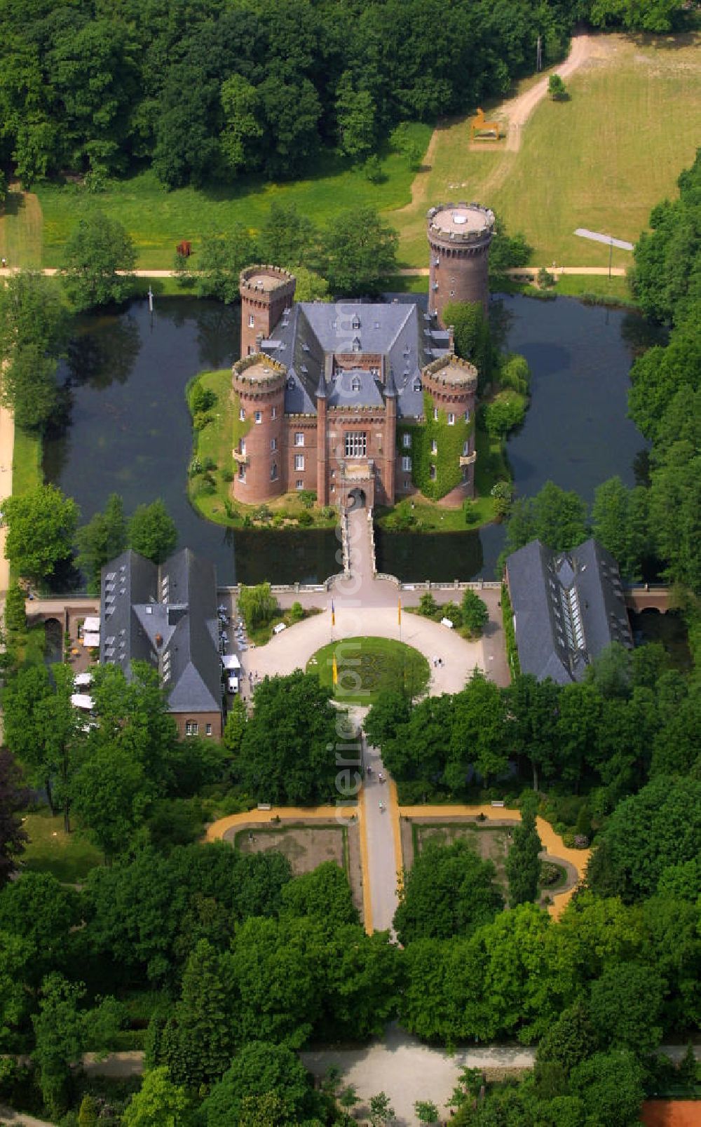 Aerial photograph Kleve - Blick auf das Schloss Moyandt. Das Wasserschloss bei Bedburg-Hau zählt zu den wichtigsten neugotischen Bauten in Nordrhein-Westfalen. Es beherbergt als Museum die umfangreiche Sammlung moderner Kunst der Gebrüder van der Grinten und ist ein beliebtes Ausflugsziel am Niederrhein. View of Castle Moyand. The moated castle at Bedburg-Hau is one of the most important neo-Gothic buildings in North Rhine-Westphalia. It houses as a museum the extensive collection of modern art of the brothers van der Grinten, and is a popular destination on the Lower Rhine.