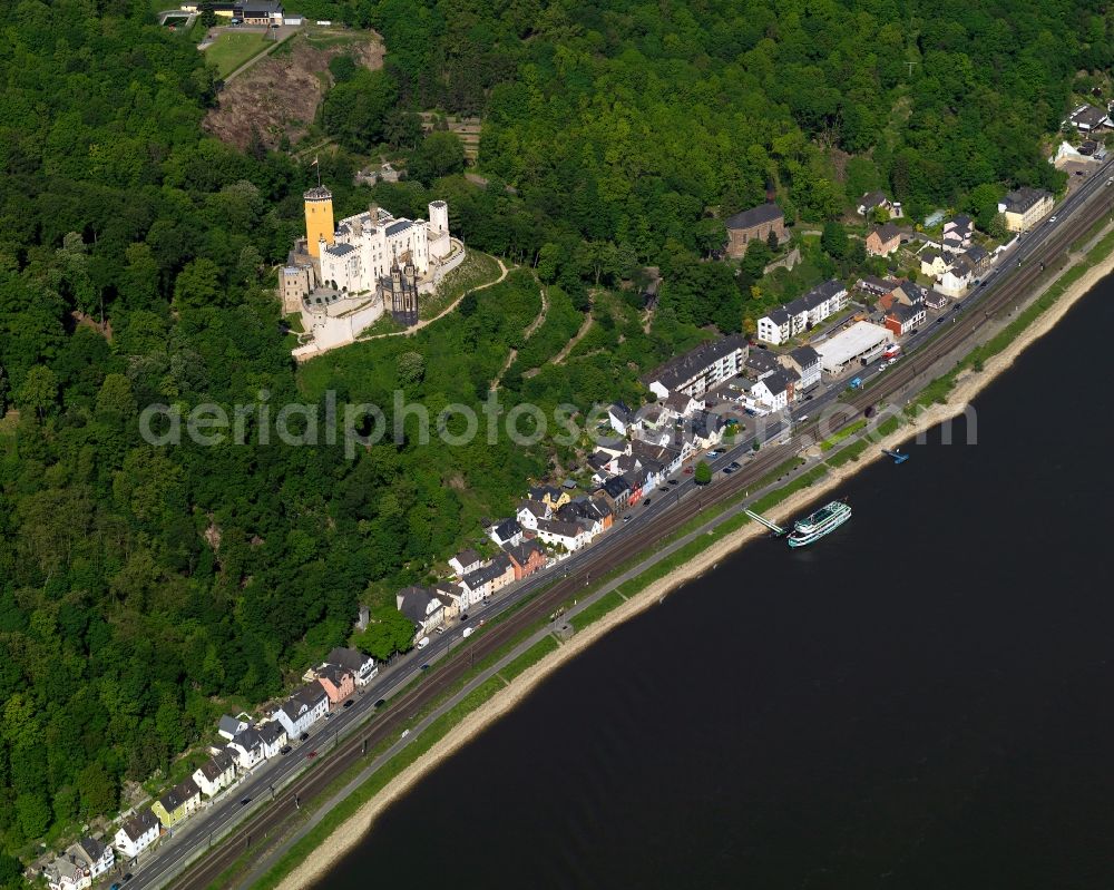 Koblenz from the bird's eye view: Stolzenfels Castle in Koblenz in the state Rhineland-Palatinate. The castle is located on the riverbank of the river Rhine, opposite Lahnstein. The former fortress was rebuilt as a castle in the Rhine romantic style. Railway tracks run in front of it