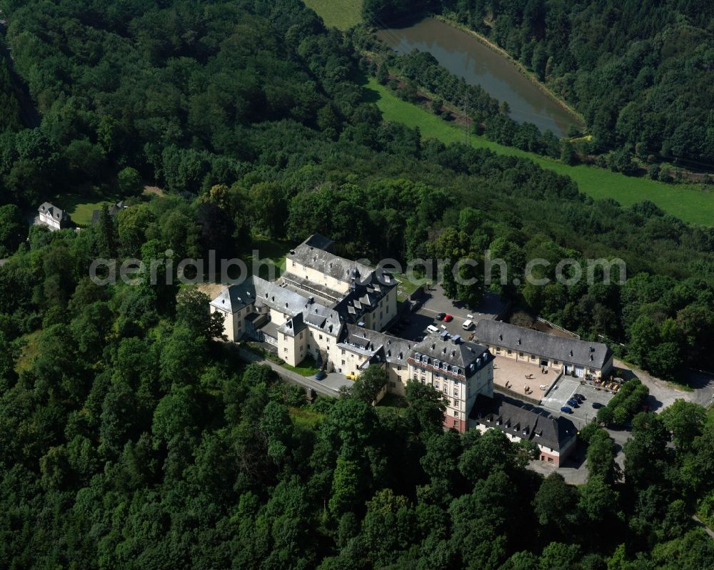 Bad Laasphe from the bird's eye view: Wittgenstein Castle in Bad Laasphe in the state of North Rhine-Westphalia. Its unregular three winged shape was built in several construction phases without a specific style. It is surrounded by forest on a 470m high mountain