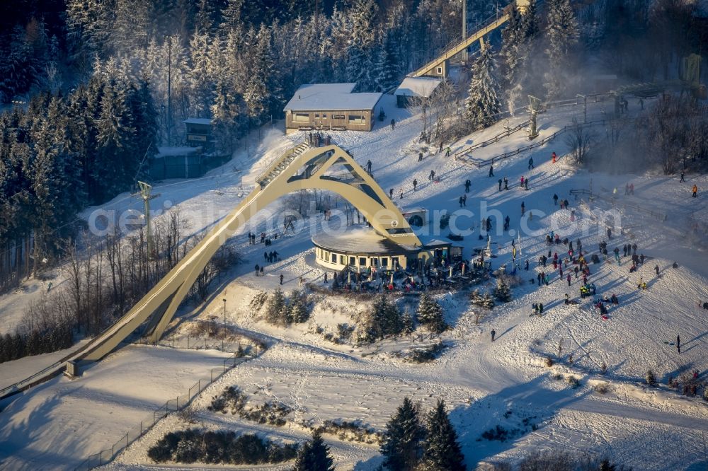 Winterberg from above - Snowy ski slopes and downhill skiing in the winter sports areas in Winterberg in North Rhine-Westphalia