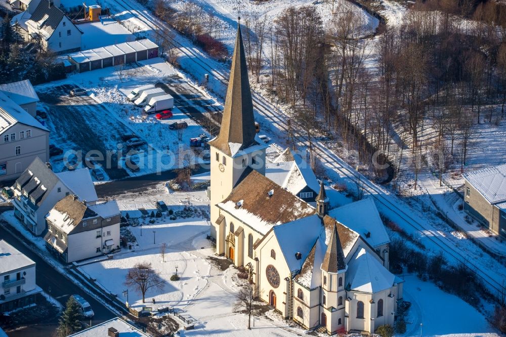 Aerial image Olsberg - Wintry snowy church building Pfarrkirche St. Martin im Stadtteil Bigge in Olsberg in the state North Rhine-Westphalia