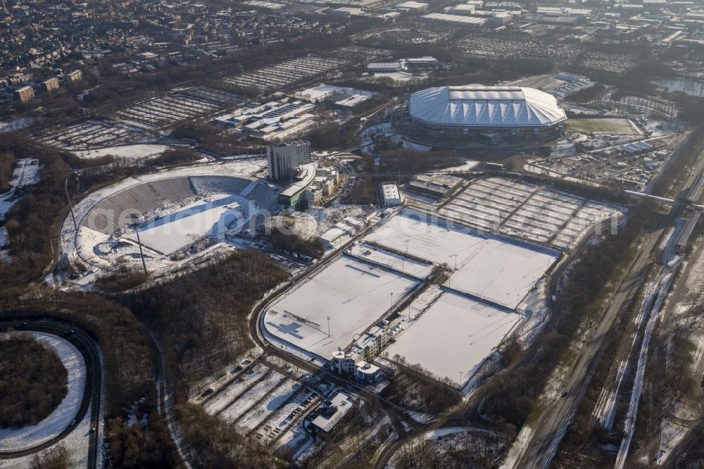 Aerial image Gelsenkirchen - Snow-covered and winterly Park Stadium and Veltins-Arena in Gelsenkirchen in the state of North Rhine-Westphalia. The arena is the stadium of FC Schalke 04. It was completed in 2001 and has been used instead of the old - still remaining - park stadium. Apart from football games, the stadium can be used for different events