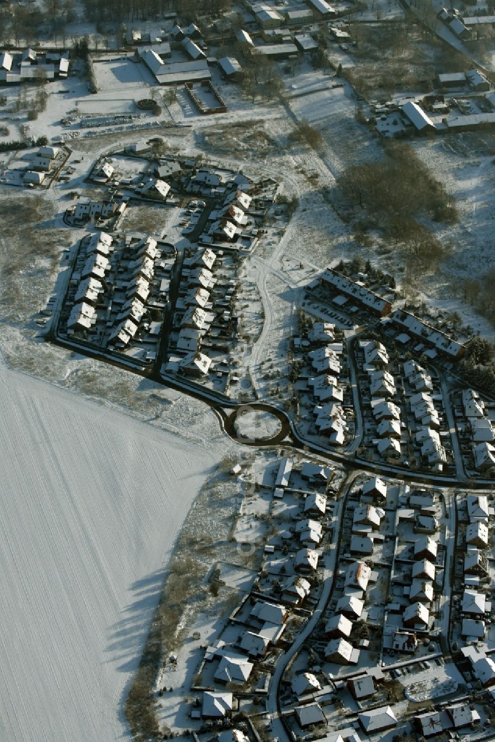 Altlandsberg from above - Snow-covered single-family residential area in the West of the village of Wegendorf in the state of Brandenburg. The residential area is located around streets at a roundabout