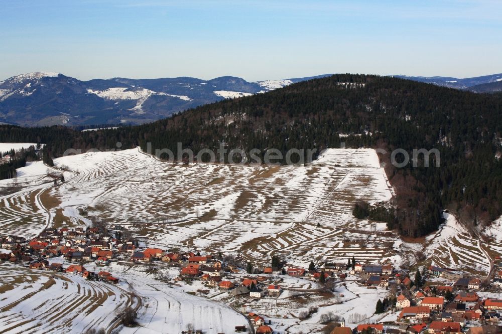 Schopfheim from above - Winter landscape with snow remains on the mountain ridge of Gersbach, a district of Schopfheim in Baden-Wuerttemberg. On the mountain summit in the rear five wind turbines are planned to be installed