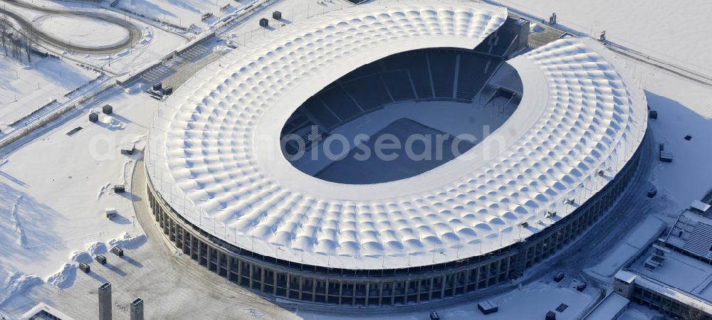 Aerial photograph Berlin - Der winterlich Blick auf das Berliner Olympiastadion. Im Bild Schneeräumarbeiten auf dem Olympischen Platz am Stadion gegenüber dem Gutsmuthsweg. The winter view of the Berlin Olympic stadium.