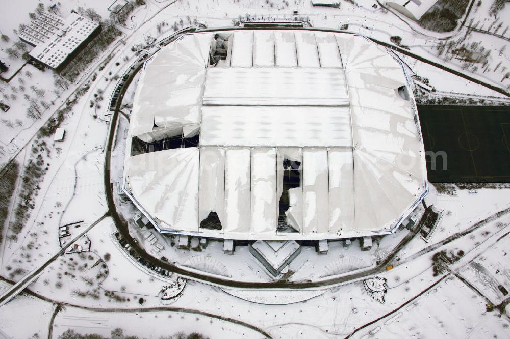 GELSENKIRCHEN from above - Einsatzkräfte schieben Schnee vom Dach der Veltins-Arena in Gelsenkirchen. Der Schaden am Dach der Arena des Fußball-Bundesligisten FC Schalke 04 wird immer größer. Durch die Schneemassen auf der multifunktionalen Spielstätte in Gelsenkirchen sind die empfindlichen Dachmembranen inzwischen an sechs Stellen und auf einer Fläche von etwa 6000 Quadratmetern beschädigt. Am Sonntag hatte der Club bereits den für den 30. Dezember vorgesehenen Biathlon-Wettbewerb abgesagt, da die Sicherheit der Zuschauer nicht gewährleistet werden konnte. Snow damage to the roof of the Schalke - Arena in Gelsenkirchen.