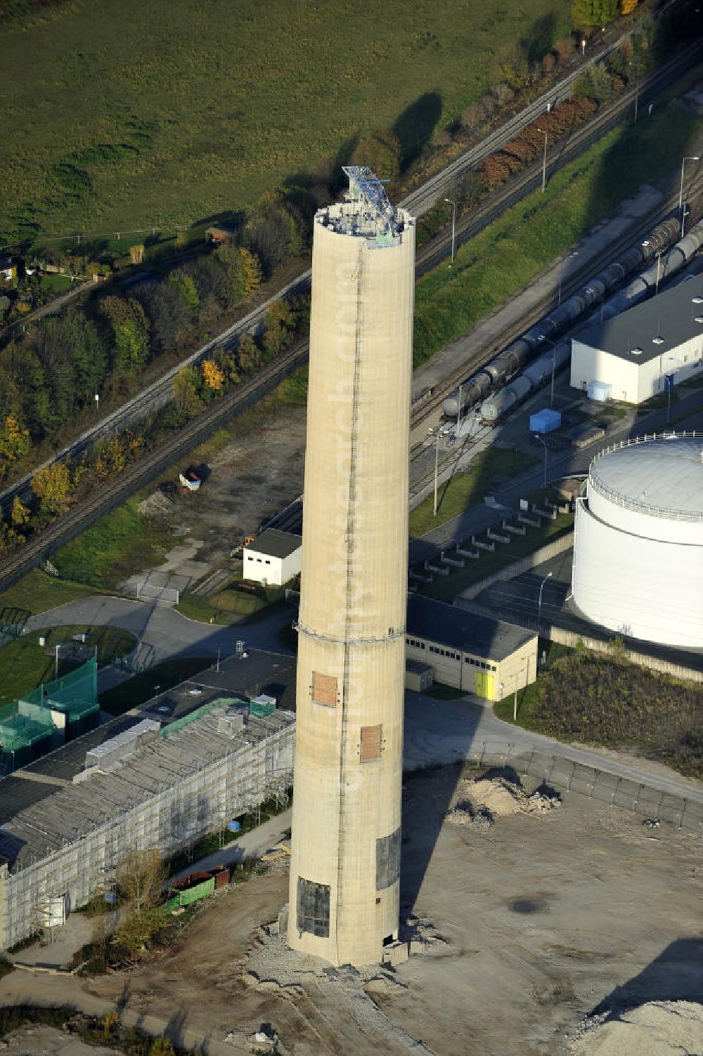 Aerial photograph Gera - Blick auf die Abrißbaustelle der letzten Esse / Industrieschornstein im einstigen Heizkraftwerk Gera-Nord. Im Auftrag der Thüringer Landesentwicklungsgesellschaft (LEG) knabbern Industriefräsen die Reste des letzten Schornsteines ab, der einst mit zwei weiteren das Wahrzeichen Geras bildete. Demolition site of the last chimney / industrial chimney in the former power station Gera-Nord.