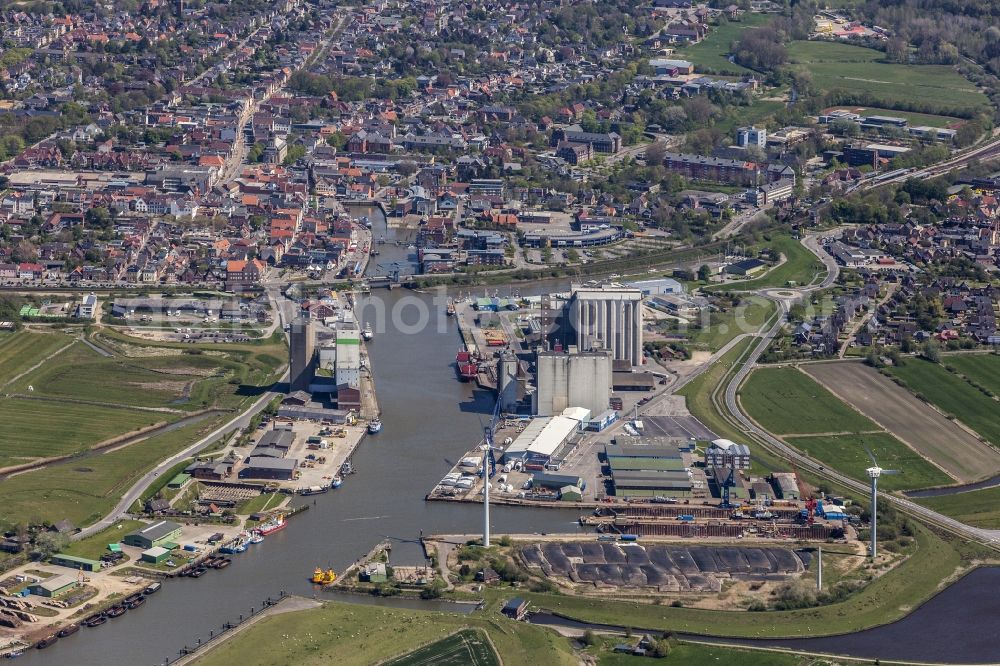 Aerial image Husum - Wharfs and ship landing stages of the sea navigation with loading grain and fertilizer in the inland harbour in the district of Roedemis in Husum in the federal state Schleswig-Holstein. Look about the southwest part of the town