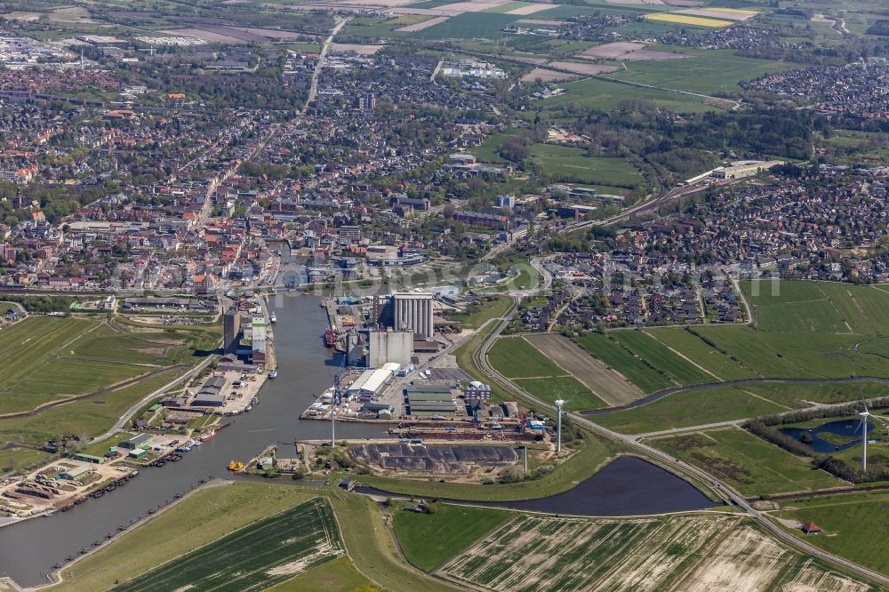 Aerial photograph Husum - Wharfs and ship landing stages of the sea navigation with loading grain and fertilizer in the inland harbour in the district of Roedemis in Husum in the federal state Schleswig-Holstein. Look about the southwest part of the town