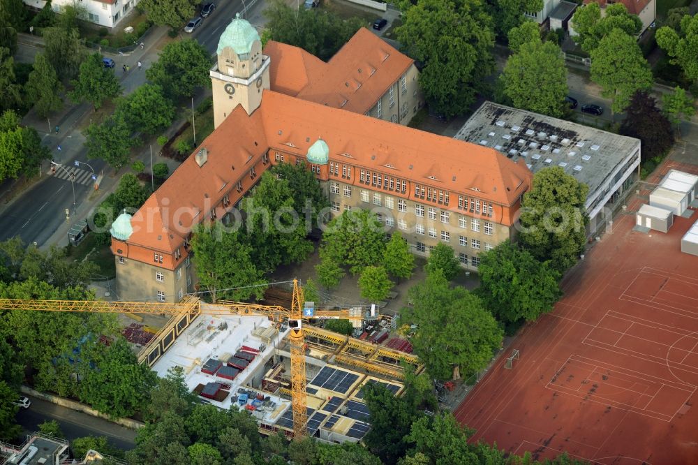 Aerial photograph Berlin - School grounds, building complex and construction works at Arndt-Gymnasium Dahlem in the district of Steglitz-Zehlendorf in Berlin in Germany. A new building is being developed next to the historic main building with the red roof, small towqer and green dome