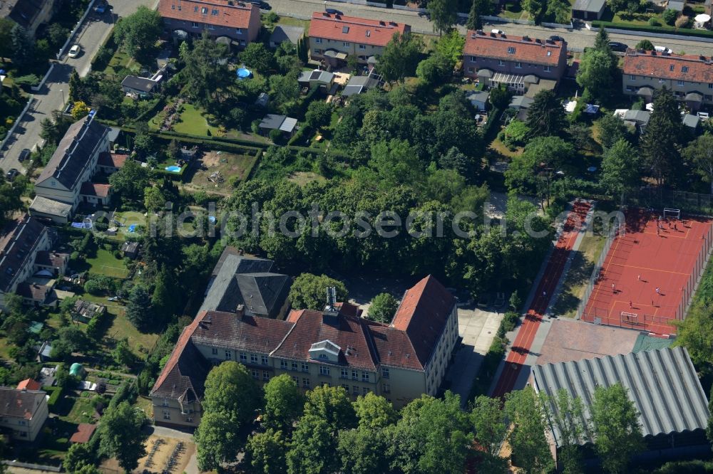 Aerial photograph Berlin - School grounds and buildings of the Fritz-Kuehn-School in the Bohnsdorf part of the district of Treptow-Koepenick in Berlin in Germany. The integrated secondary school with its historic main building and sports facilities is located between trees and green spaces on Dahmestrasse