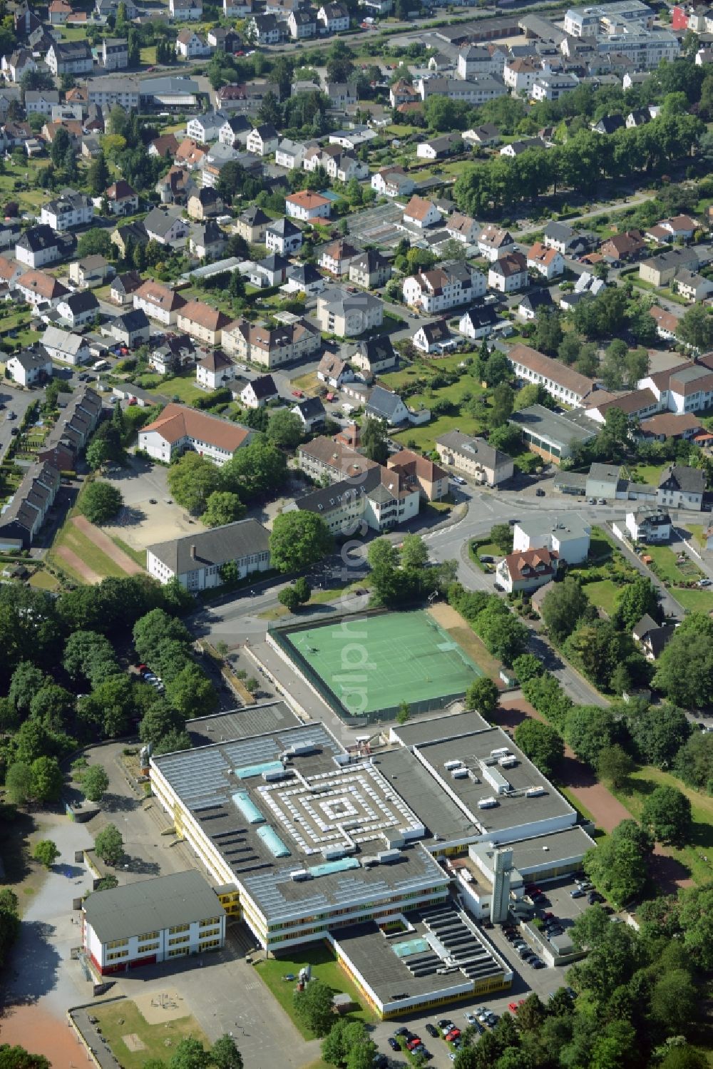 Fröndenberg/Ruhr from the bird's eye view: School grounds and buildings of the comprehensive school in Froendenberg/Ruhr in the state of North Rhine-Westphalia. A tennis court is located next to the large school building. The compound is located in the North of the town in the Unna county district