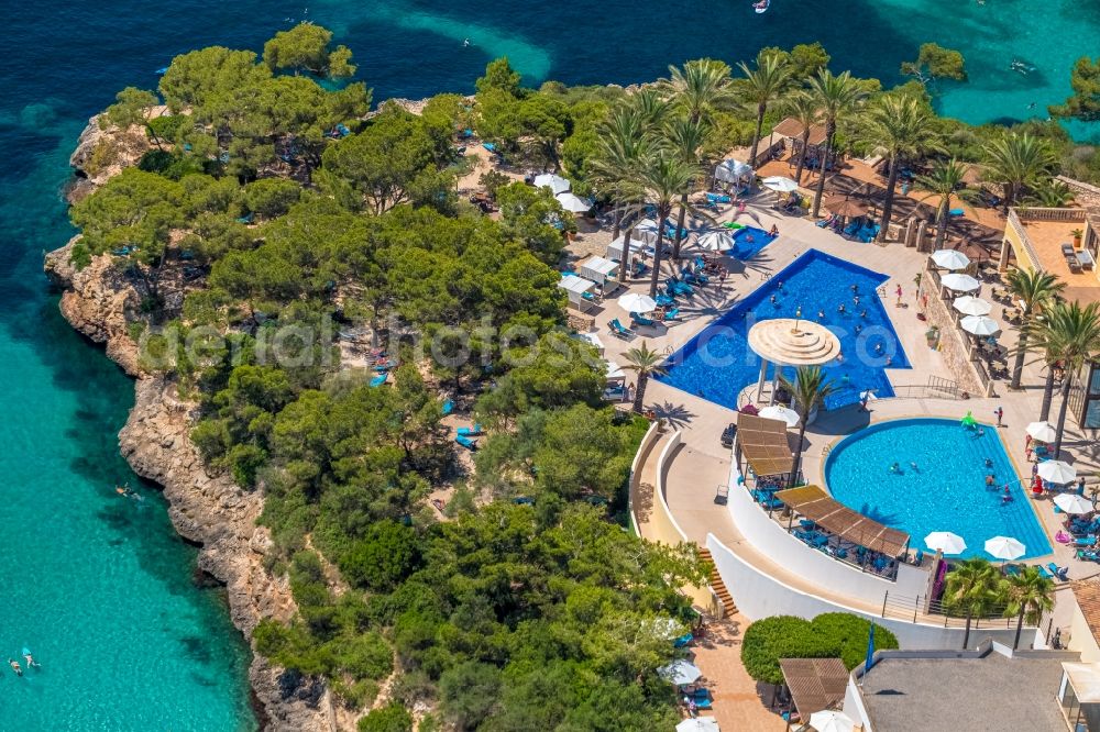 Cala D'or from the bird's eye view: Refreshing swim in the blue pool - swimming pool of Hotel Robinson Cala Serena in Cala D'or in Balearic island of Mallorca, Spain