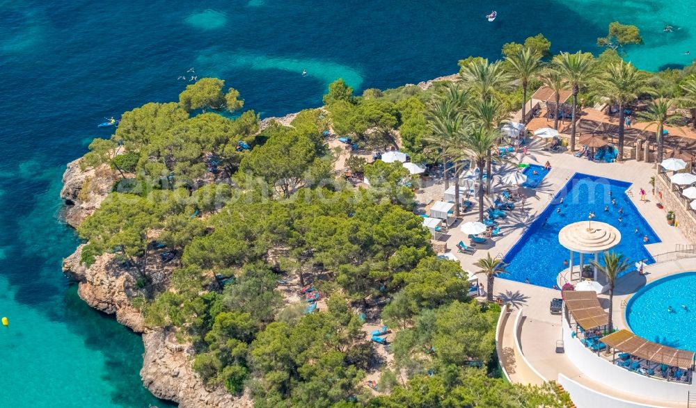 Aerial image Cala D'or - Refreshing swim in the blue pool - swimming pool of Hotel Robinson Cala Serena in Cala D'or in Balearic island of Mallorca, Spain