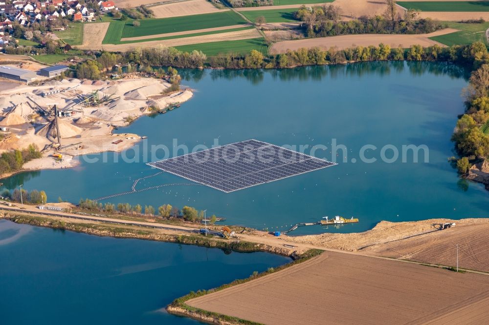 Aerial photograph Leimersheim - Floating solar power plant and panels of photovoltaic systems on the surface of the water on a quarry pond for gravel extraction in Leimersheim in the state Rhineland-Palatinate, Germany