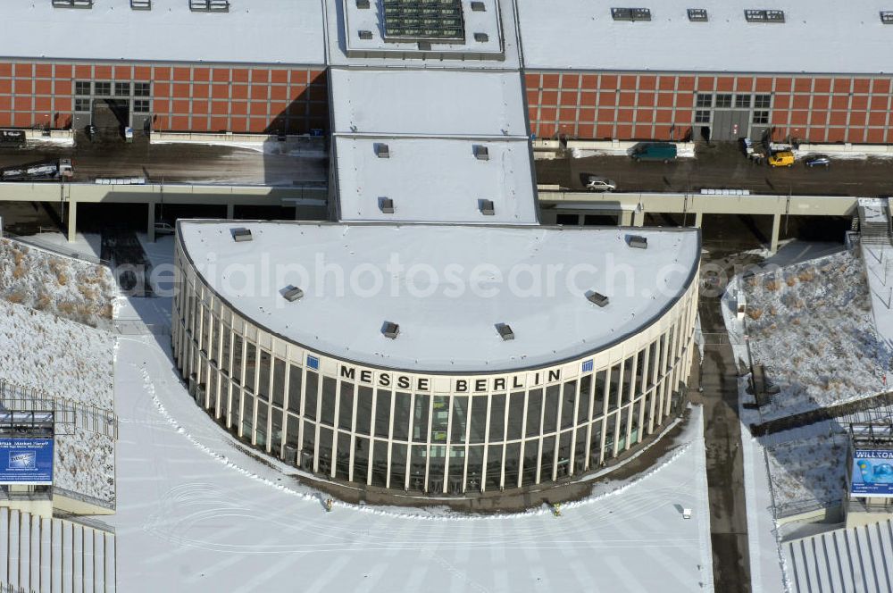 Aerial photograph Berlin - Blick auf den winterlich verschneiten Südeingang zum Messegelände am Berliner Funkturm. Das Messegelände in Berlin liegt im Ortsteil Westend des Bezirks Charlottenburg-Wilmersdorf zwischen der Masurenallee (gegenüber dem Haus des Rundfunks), dem Messedamm und der Jafféstraße. Das Areal umfasst 26 Messehallen mit 160.000 m² Hallenfläche. Die Hallen sind miteinan der verbunden und es ist möglich, mehrere Hallen für bestimmte Veranstaltungen – abhängig von der Größe – zusammenzufassen. Ein flexibles Leitsystem bietet dem Besucher Orientierung bei seinem Messebesuch.