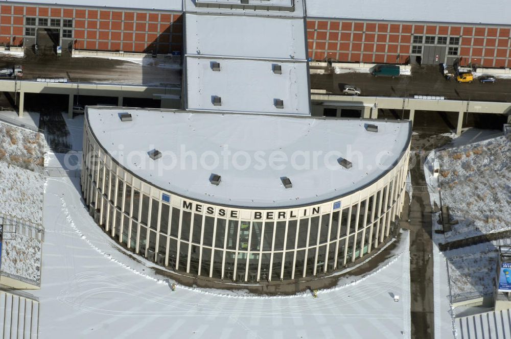 Berlin from above - Blick auf den winterlich verschneiten Südeingang zum Messegelände am Berliner Funkturm. Das Messegelände in Berlin liegt im Ortsteil Westend des Bezirks Charlottenburg-Wilmersdorf zwischen der Masurenallee (gegenüber dem Haus des Rundfunks), dem Messedamm und der Jafféstraße. Das Areal umfasst 26 Messehallen mit 160.000 m² Hallenfläche. Die Hallen sind miteinan der verbunden und es ist möglich, mehrere Hallen für bestimmte Veranstaltungen – abhängig von der Größe – zusammenzufassen. Ein flexibles Leitsystem bietet dem Besucher Orientierung bei seinem Messebesuch.