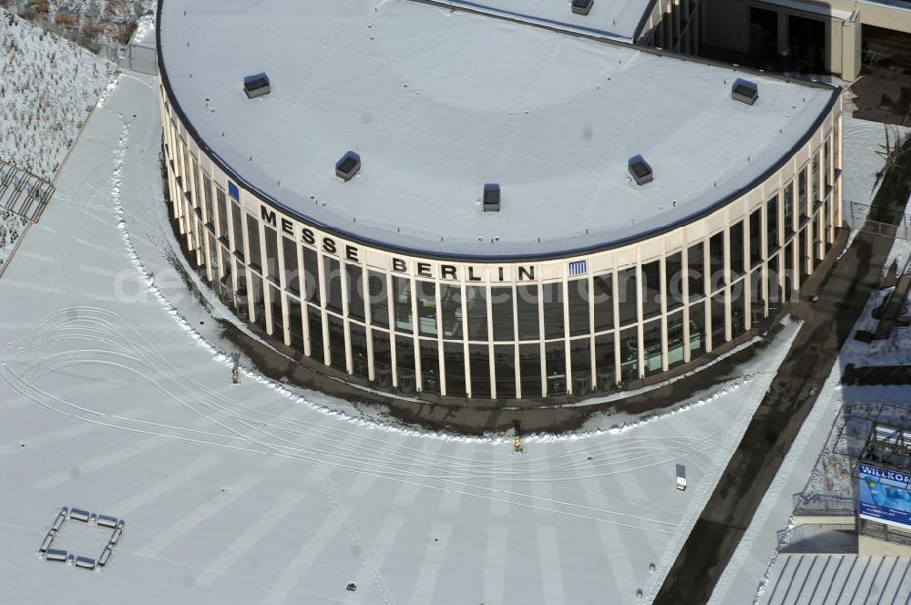 Aerial image Berlin - Blick auf den winterlich verschneiten Südeingang zum Messegelände am Berliner Funkturm. Das Messegelände in Berlin liegt im Ortsteil Westend des Bezirks Charlottenburg-Wilmersdorf zwischen der Masurenallee (gegenüber dem Haus des Rundfunks), dem Messedamm und der Jafféstraße. Das Areal umfasst 26 Messehallen mit 160.000 m² Hallenfläche. Die Hallen sind miteinan der verbunden und es ist möglich, mehrere Hallen für bestimmte Veranstaltungen – abhängig von der Größe – zusammenzufassen. Ein flexibles Leitsystem bietet dem Besucher Orientierung bei seinem Messebesuch.