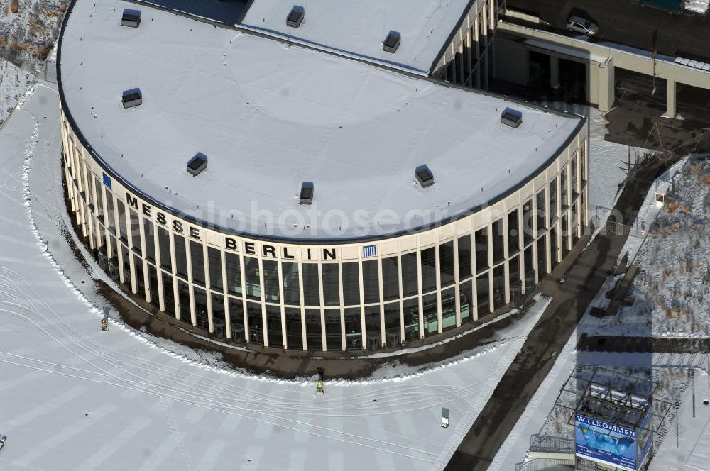 Berlin from above - Blick auf den winterlich verschneiten Südeingang zum Messegelände am Berliner Funkturm. Das Messegelände in Berlin liegt im Ortsteil Westend des Bezirks Charlottenburg-Wilmersdorf zwischen der Masurenallee (gegenüber dem Haus des Rundfunks), dem Messedamm und der Jafféstraße. Das Areal umfasst 26 Messehallen mit 160.000 m² Hallenfläche. Die Hallen sind miteinan der verbunden und es ist möglich, mehrere Hallen für bestimmte Veranstaltungen – abhängig von der Größe – zusammenzufassen. Ein flexibles Leitsystem bietet dem Besucher Orientierung bei seinem Messebesuch.