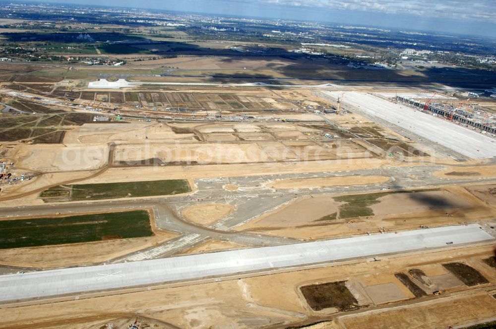 Schönefeld from the bird's eye view: Blick über die südliche Landebahn / Startbahn auf den Neubau der Gleisanlagen der Deutschen Bahn aus Richtung Selchower Kurve zur Anbindung an die Großbaustelle Flughafen Berlin-Schönefeld BBI. Ausführende Firmen: Hochtief AG; EUROVIA Beton; PORR; BERGER Bau; Kark Weiss; Matthai; Schäler Bau Berlin GmbH; STRABAG; MAX BÖGL