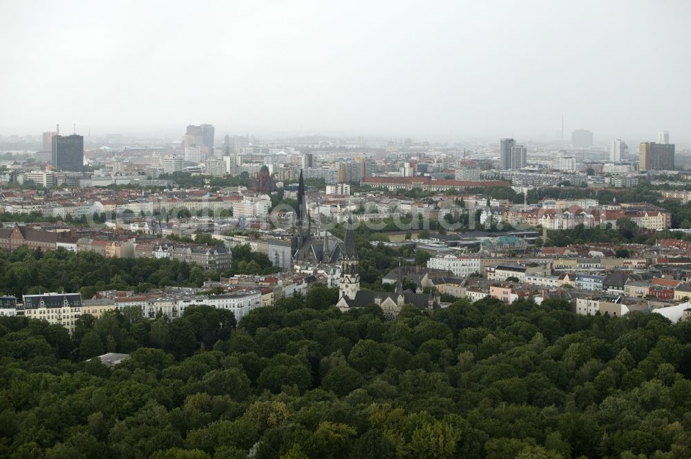 Berlin from the bird's eye view: On Suedstern in the Kreuzberg district of Berlin in Germany Berlin extend two churches from the densely populated residential area. The Church at Suedstern is an Evangelical Free Church of charismatic Christian Center Berlin eV. She was built in the late 19th century in neo-Gothic style as Military church. The Basilica of St. John is a listed Roman Catholic parish church and the largest Catholic church building in Berlin. On the grounds of the church is the Papal Nunciature of Berlin. In the background the skyscrapers on Potsdamer Platz, the Springer premises and the tower of the Postbank Financial Center can be seen