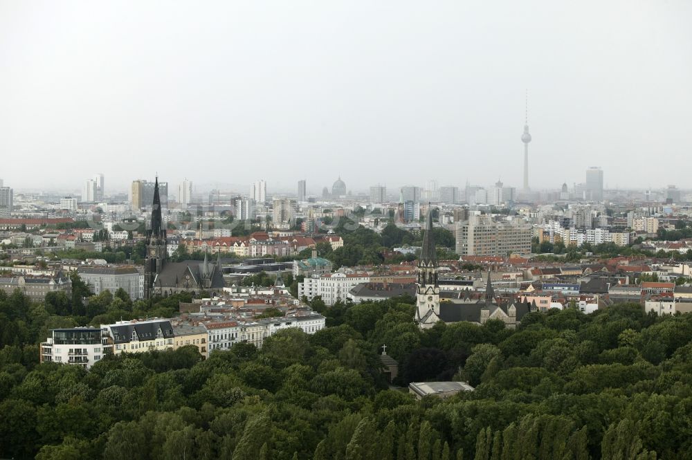 Aerial photograph Berlin - On Suedstern in the Kreuzberg district of Berlin in Germany Berlin extend two churches from the densely populated residential area. The Church at Suedstern is an Evangelical Free Church of charismatic Christian Center Berlin eV. She was built in the late 19th century in neo-Gothic style as Military church. The Basilica of St. John is a listed Roman Catholic parish church and the largest Catholic church building in Berlin. On the grounds of the church is the Papal Nunciature of Berlin. In the background the Berlin TV Tower, the Hotel ParkInn at Alexanderplatz, the Springer tower and the Berlin Cathedral are visible from afar