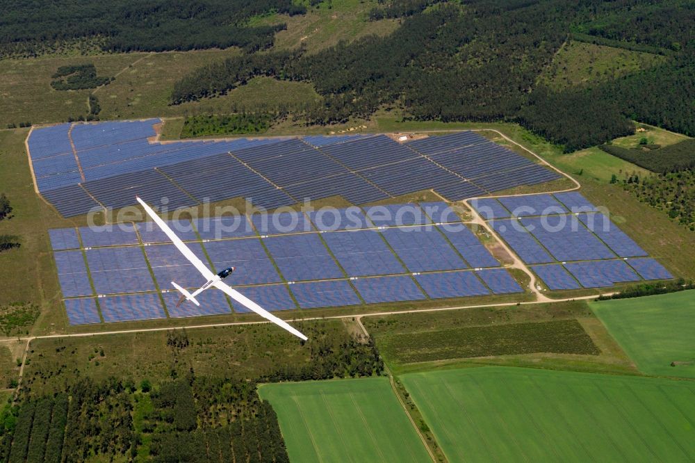 Marienfließ from above - Glider and sport aircraft Arcus M flying over the airspace of solar energy field in Marienfliess in the state Brandenburg, Germany