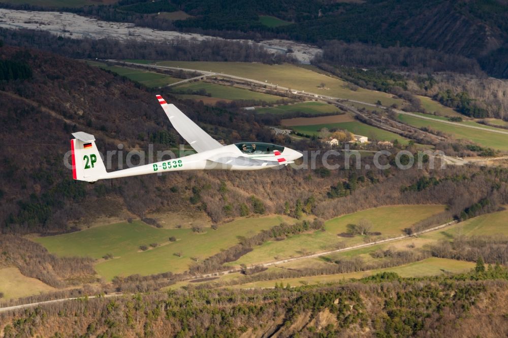 Aspremont from above - Glider and sport airplane ASW 20 D-6538 in flight over autumn forest at Aspremont in Provence-Alpes-Cote d'Azur, France