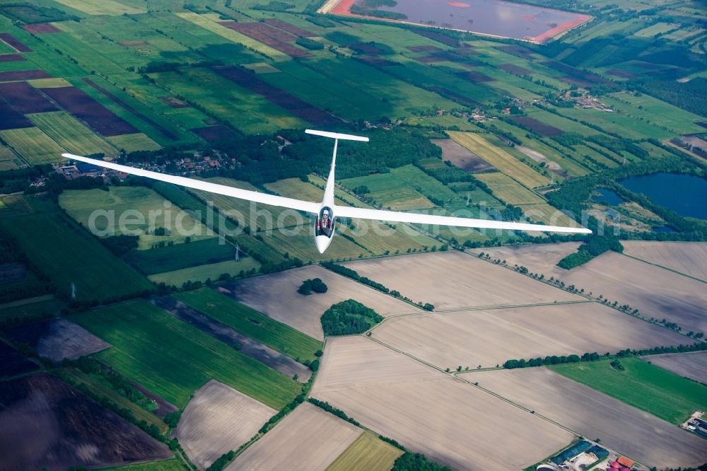 Aerial photograph Stade - High performance glider ASW 20 in flight over the fields and red mud dump near Stade-Buetzfleth in Lower Saxony, Germany. An aluminum production waste product is deposited here