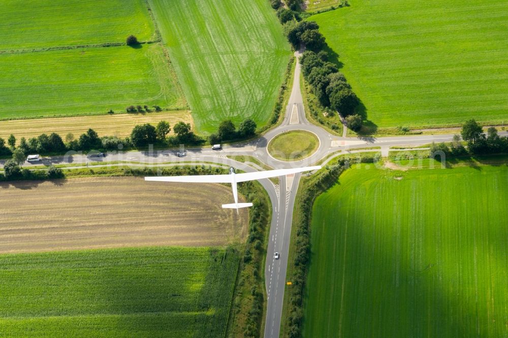 Aerial photograph Stade - Glider and sport aircraft SF-27 flying over the meadows and a roundabout near Stade in the state Lower Saxony, Germany