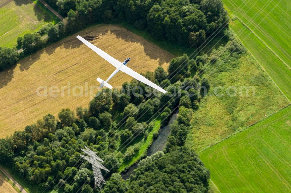 Stade from above - Glider and sport aircraft SF-27 flying over the meadows and a hHigh-voltage line near Stade in the state Lower Saxony, Germany