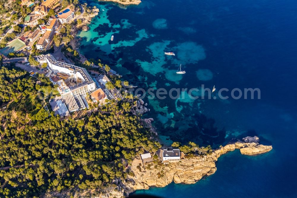 Cala Fornells from the bird's eye view: Sailboat under way in the bay Cala Fornells overlooking the hotel complexes of Hotel Cala Fornells and Hotel Coronado Thalasso & Spa along the Carretera de Cala Fornells in Cala Fornells in Balearic island of Mallorca, Spain