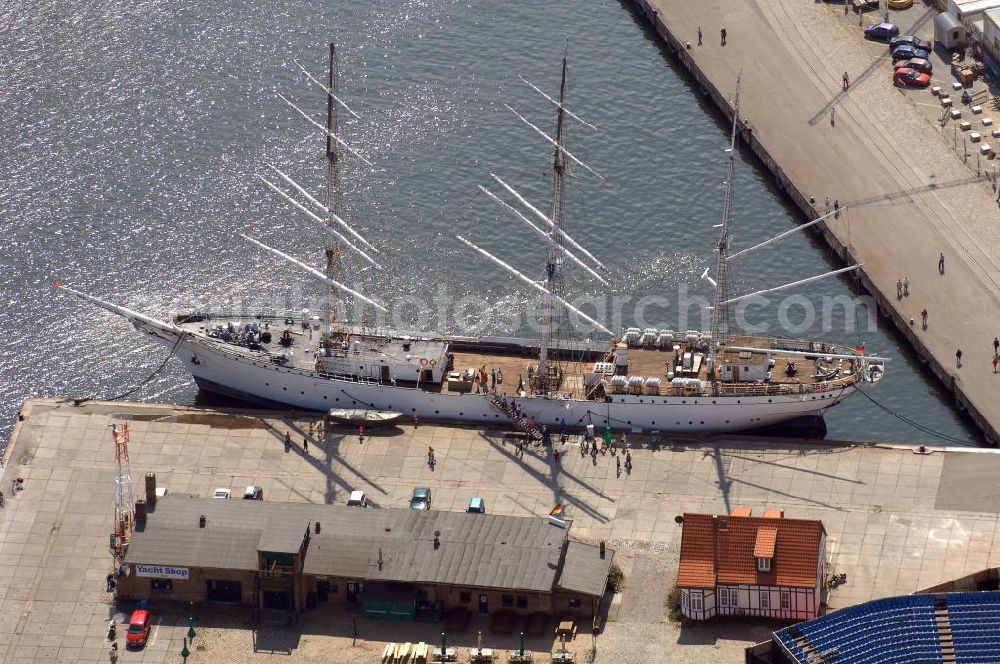 STRALSUND from above - Das Segelschiff Gorch Fock I angelegt an ihrem Heimathafen Stralsund. Bis Ende April 1945 war die bei Blohm+Voss in Hamburg gebaute Gorch Fock in Stralsund beim 1. Schiffsstammregiment als Kadetten-Schulschiff zu Hause. Sie überstand alle Bombenangriffe unbeschadet, bis sie am 30. April 1945 von einem Sprengkommando vor der Hansestadt versenkt wurde. Bis Mitte 1947 rostete das Wrack etwa 150 m südwestlich der rügenschen Halbinsel Drigge vor sich hin. Dann wurde sie geborgen und im Juni 1947schwamm die „Gorch Fock“ wieder. Am 15. Juni 1951 wurde sie nach Reparaturarbeiten unter sowjetische Flagge als „Towarischtsch“ erneut in den Dienst gestellt. Seit dem 25. September 2003 ist die ,,Gorch Fock wieder in ihrem alten Heimathafen zu Hause und zu besichtigen. Adresse: Hafen/Ballastkiste, 18439 Stralsund, Betriebsleitung: Nicole Merten, Bord-Tel:03831 666520, Fax 03831 666519, E-Mail: info@gorchfock1.de; Förderverein Gorch Fock I e.V., Knieperstr. 20, 18439 Stralsund, Tel. 03831 305090, Fax 03831 305063, E-Mail: s.eicke@web.de;