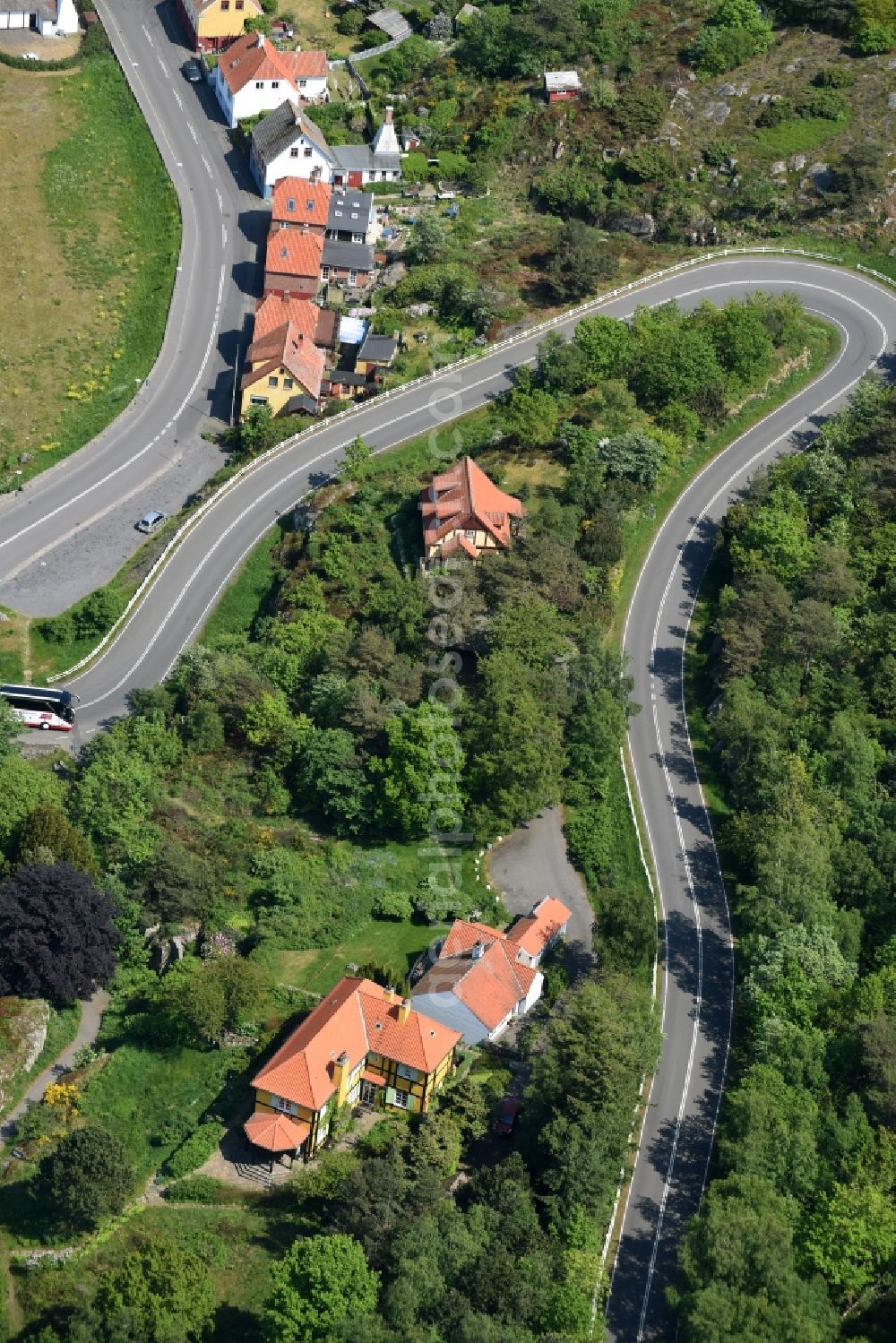 Gudhjem from the bird's eye view: Serpentine-shaped curve of a road Norresand guide in Gudhjem in Region Hovedstaden, Denmark