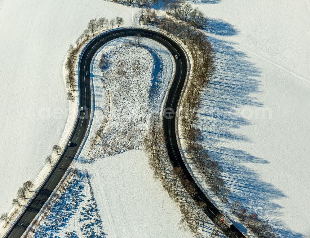 Aerial image Olsberg - Wintry snowy serpentine-shaped curve of a road guide in Olsberg in the state North Rhine-Westphalia