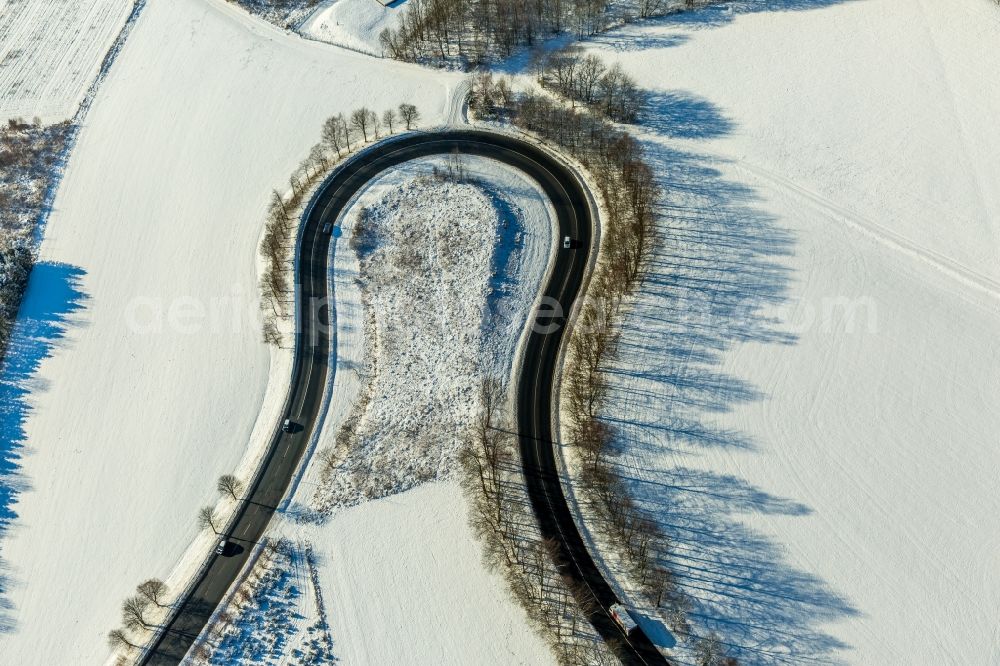 Aerial photograph Olsberg - Wintry snowy serpentine-shaped curve of a road guide in Olsberg in the state North Rhine-Westphalia