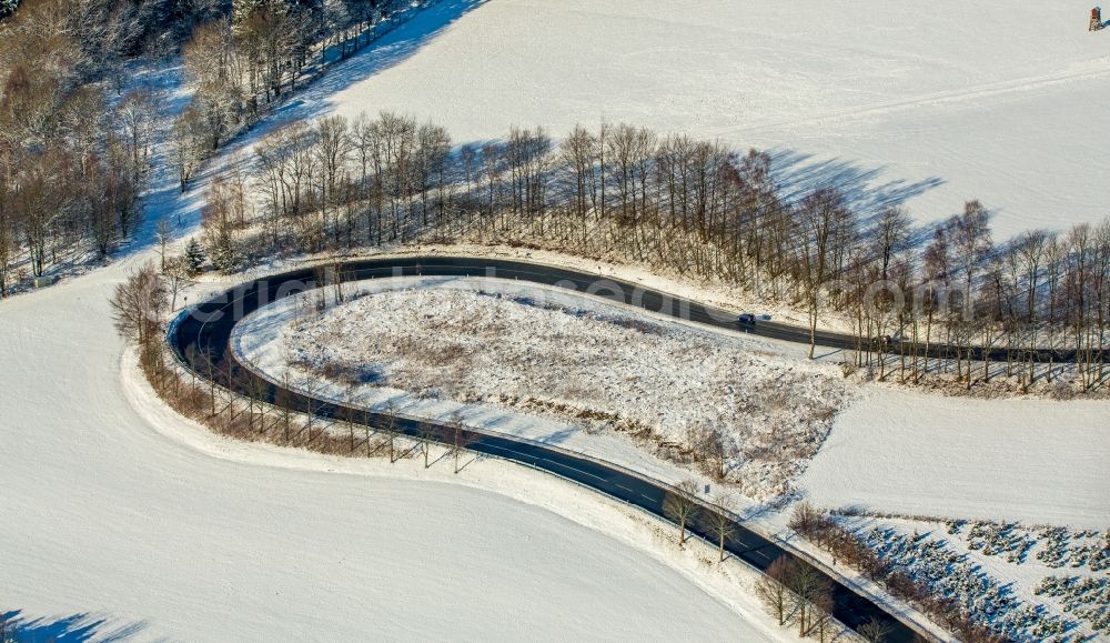 Olsberg from above - Wintry snowy serpentine-shaped curve of a road guide in Olsberg in the state North Rhine-Westphalia