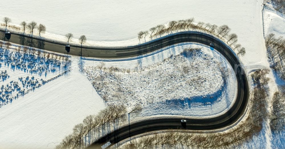 Olsberg from the bird's eye view: Wintry snowy serpentine-shaped curve of a road guide in Olsberg in the state North Rhine-Westphalia