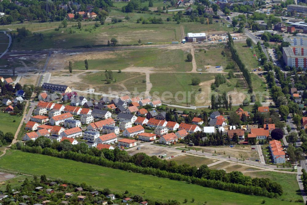 Aerial image Berlin - Berlin Ahrensfelde Die HOWOGE Wohnungsbaugesellschaft baut im Nordosten Berlins, am Gehrensee, eine idyllische Siedlung. Ca. 600 Einfamilienhäuser sollen in den nächsten zehn Jahren beim größten Eigenheimprojekt des Wohnungsunternehmens im Ortsteil Falkenberg des Bezirks Lichtenberg entstehen. Ein Landschaftsschutzgebiet, die Wald- und Seenlandschaft des Barnim, liegt direkt vor der Haustür. Gleichzeitig findet sich hier und im benachbarten Kiez all das, was zum städtischen Leben gehört: Kindergarten, Schule, gute Einkaufsmöglichkeiten, Restaurants, Arztpraxen, Tennisplatz, weitere Freizeitangebote... Der S-Bahnhof Ahrensfelde ist gut zu Fuß erreichbar. Von dort gelangt man schnell zu allen wichtigen Punkten Berlins und in 20 Minuten in die City. Speziell für die HOWOGE wurden unterschiedlichste Haustypen vom klassischen Reihenhaus über den Bungalowstil bis zur Kleinvilla entwickelt. Sie sind zwischen 86 und 127 Quadratmeter groß und kosten inklusive Grundstück zwischen 179.900 und 255.000 Euro. In punkto Exklusivität und unverbaubaren Blick ins angrenzende Landschaftsschutzgebiet ist das Haus Gehrensee der absolute Renner. Kaufinteressenten müssen sich allerdings beeilen: In vorderster Reihe und auf je ca. 500 Quadratmeter Grundfläche wird das Haus Gehrensee nur dreimal gebaut. Eines davon ist bereits verkauft.Die HOWOGE gehört zu den großen landeseigenen Wohnungsbaugesellschaften in Berlin. Sie bewirtschaftet insgesamt einen Bestand von rund 48.500 Wohnungen. In den vergangenen 15 Jahren wurden etwa 1.000 Wohnungen und 230 Eigenheime neu errichtet.