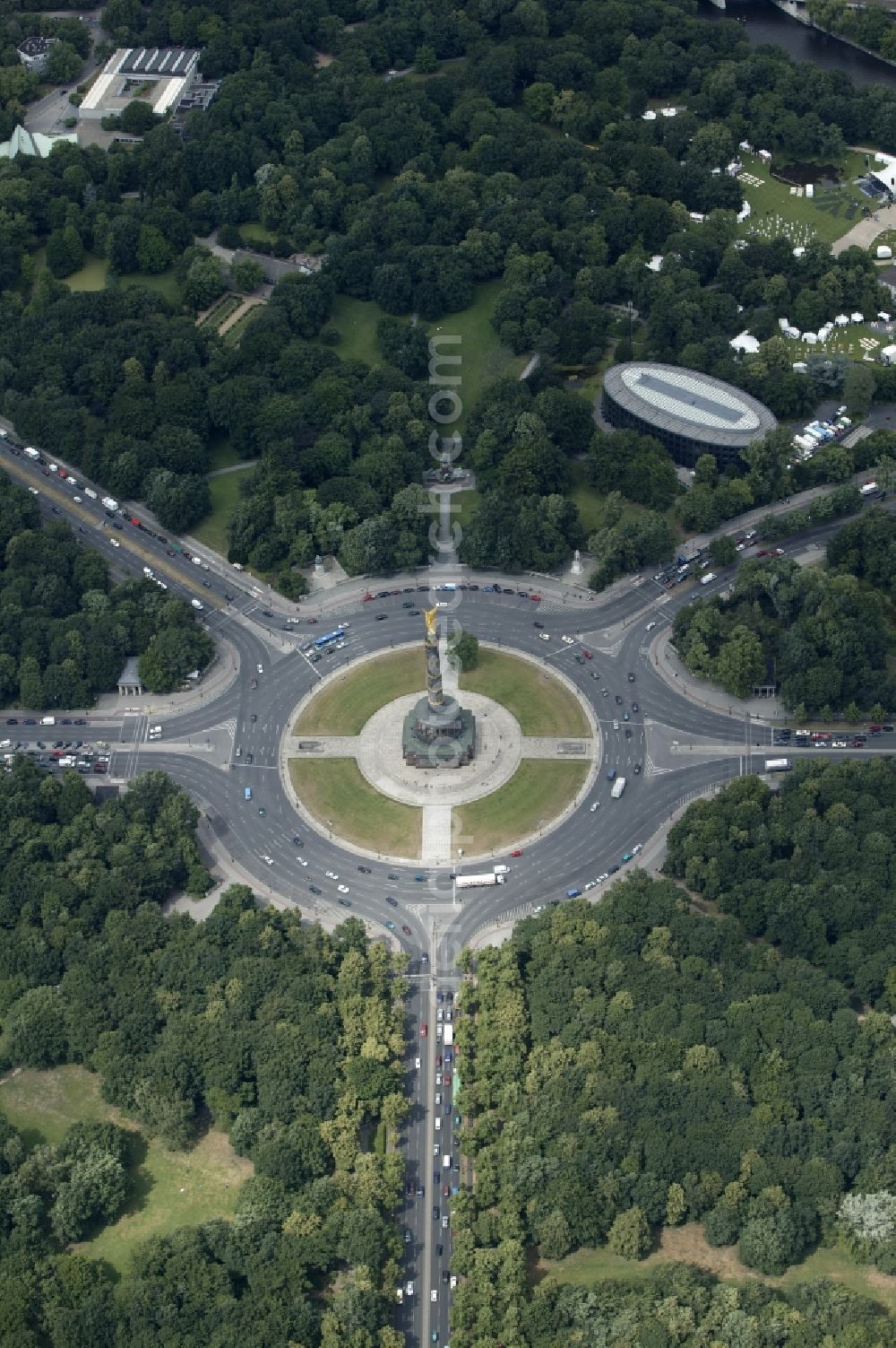 Aerial image Berlin - In the midst of the green area Tiergarten in the center of Berlin in Germany Berlin intersect at the roundabout Grosser Stern major roads of the capital. On the island of the roundabout is the Victory Column. This monument is one of the landmarks of Berlin. It was built as a national monument of the unification wars on a design by Heinrich Strack. At a high column is the gilded Victoria. The sculpture was created by Friedrich Drake. In the background the Bellevue Park can be seen. He is part of the official residence of the President. On the day of admission can be seen here the structures for the summer party of the President