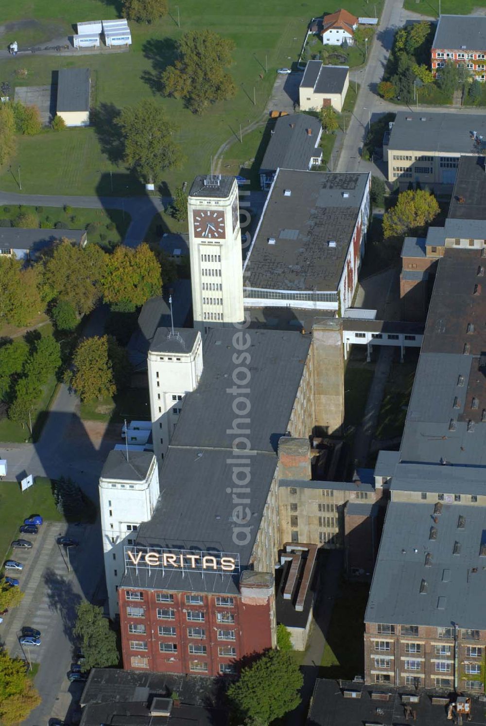 Aerial image Wittenberge - Blick auf das Gebäude der Firma Veritas an der Bad Wilsnacker Straße. Nach der Demontage des Singer-Werkes wurde die Herstellung unter dem Namen Veritas mit viel Kraftaufwand weitergeführt. Der Uhrenturm des ehemaligen Nähmaschinenwerkes SINGER/VERITAS in Wittenberge ist die größte Turmuhr Deutschlands und zweitgrößte Turmuhr in Europa – nach Big Ben in London. Die architektonischen Formen des gelb verputzten Turms lassen eine Beeinflussung durch den Expressionismus und vor allem die Neue Sachlichkeit erkennen.