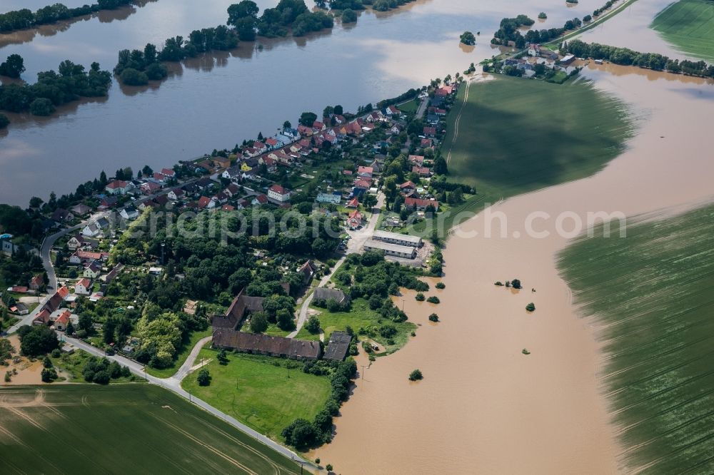 Nünchritz from the bird's eye view: The situation during the flooding in East Germany on the bank of the river Elbe in the village of Grödel by Nünchritz in the rural district of Meißen in the state of Saxony. The whole village is enclosed by the water