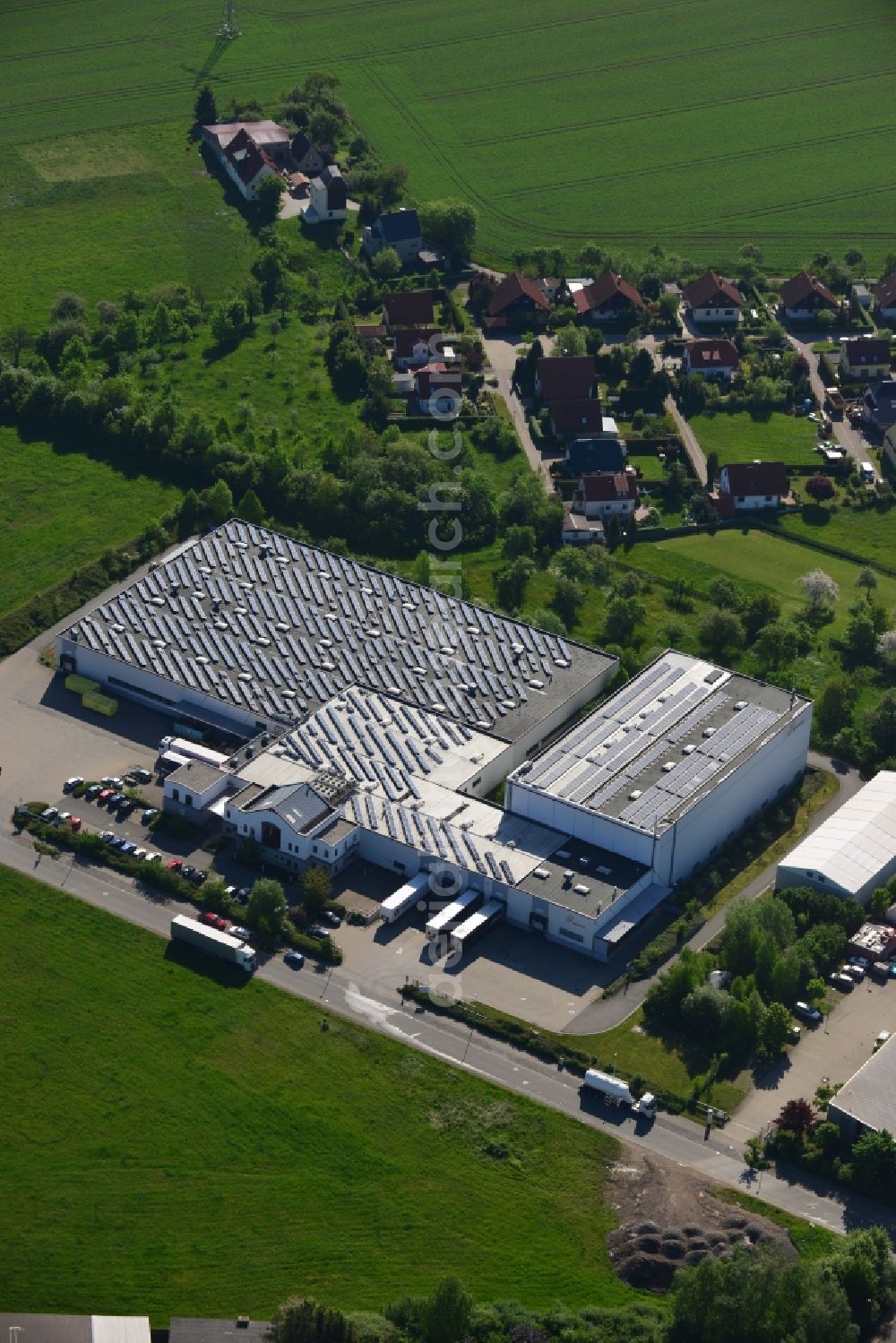 Pölzig from above - Seat and company building of the HECATEC GmbH in the commerce area in Poelzig in the state of Thuringia. The white building with the parking lot is located in an industrial area. Hecatec is a producer of disposable material made from pulp