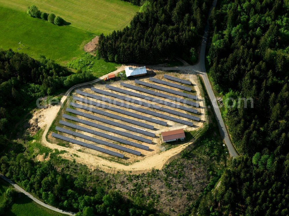 Grainet from above - The solar plant in Grainet in the county district of Freyung-Grafenau in the state of Bavaria. The collectors are surrounded by fields, woods and acres and are placed symmetrically to collect the solar energy. The energy is then used to generate heat as well as power