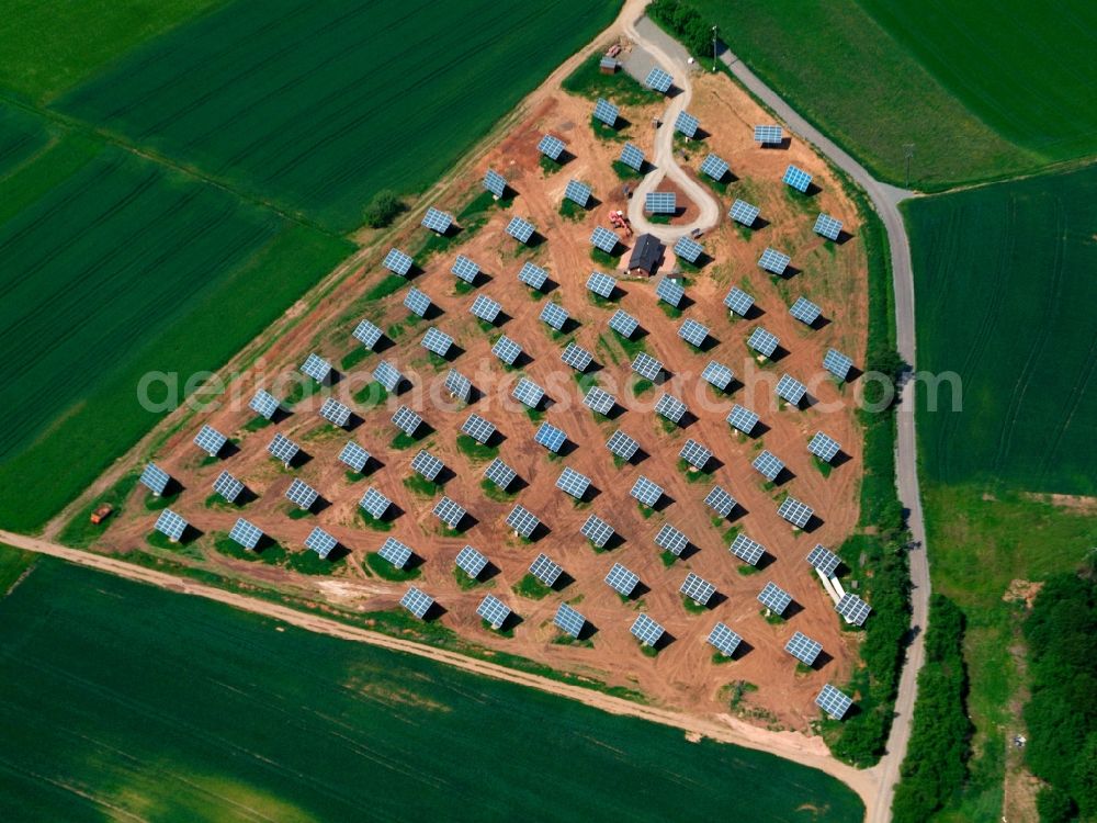 Aerial image Alheim - The solar plant in the Sterkelshausen part of the county of Alheim in the state of Hessen. The collectors are surrounded by fields and acres and are placed symmetrically to collect the solar energy. The energy is then used to generate heat as well as power