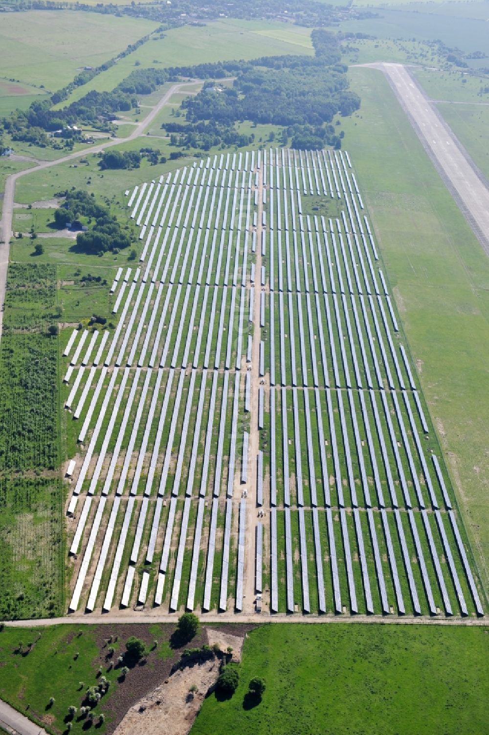 Aerial image Werneuchen - Die fast abgeschlossenen Bauarbeiten für den Solarpark / die Photovoltaikanlage Werneuchen. Die mit der Solaranlage zu bebauende Fäche befindet sich nordwestlich der Start- und Landebahn vom Sonderlandeplatz / Flugplatz Werneuchen. Ein Projekt der S Quadrat Werneuchen Grundstücks GmbH & Co. KG. Construction preparation for the Solar Park / photovoltaic system Werneuchen.