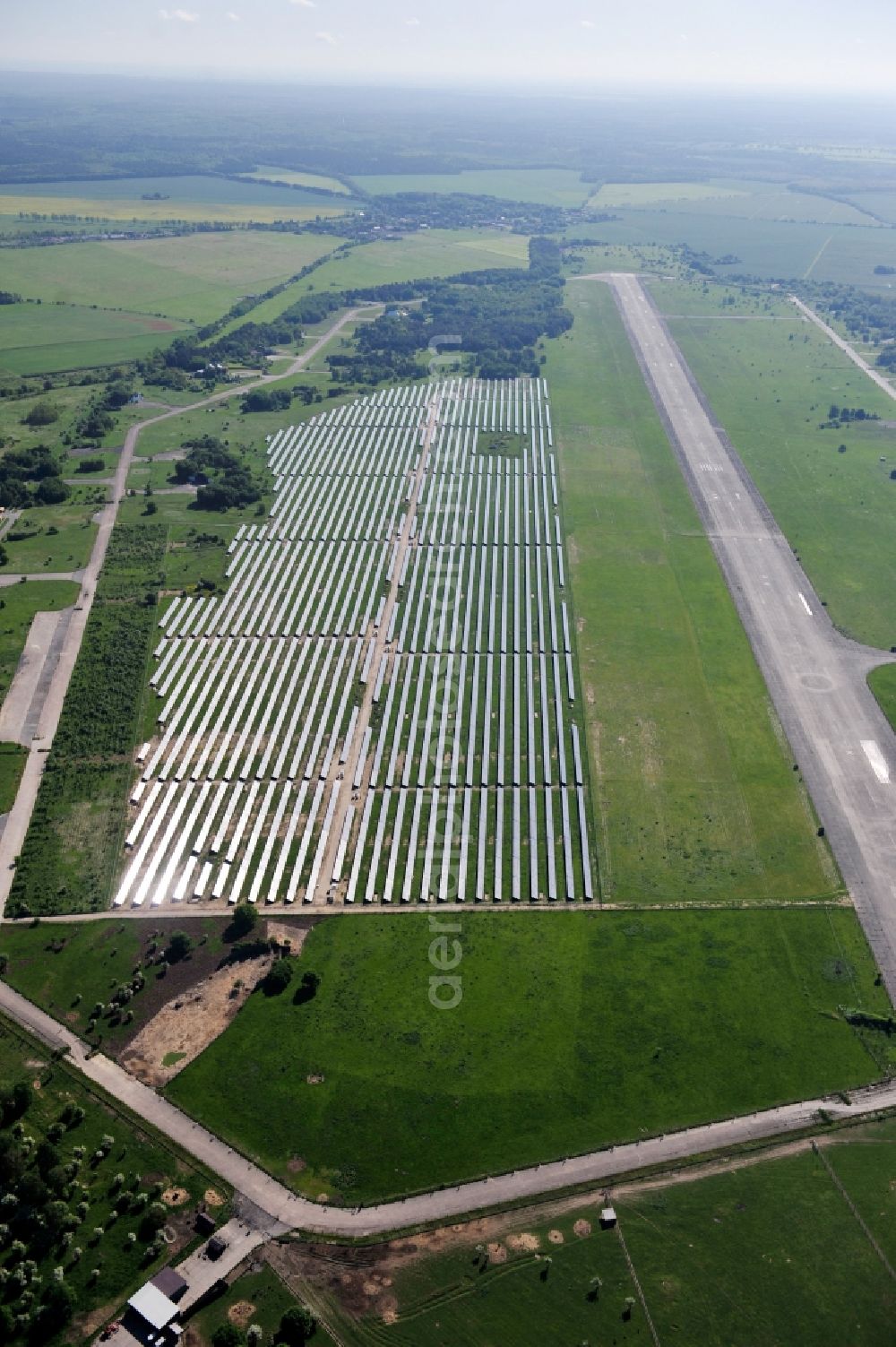 Aerial photograph Werneuchen - Die fast abgeschlossenen Bauarbeiten für den Solarpark / die Photovoltaikanlage Werneuchen. Die mit der Solaranlage zu bebauende Fäche befindet sich nordwestlich der Start- und Landebahn vom Sonderlandeplatz / Flugplatz Werneuchen. Ein Projekt der S Quadrat Werneuchen Grundstücks GmbH & Co. KG. Construction preparation for the Solar Park / photovoltaic system Werneuchen.