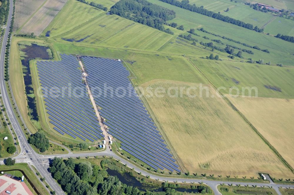 Boizenburg from the bird's eye view: Boizenburg 08/07/2012 Newly built solar panel, photovoltaic solar park or along the road 5 on the industrial and commercial area of the eastern edge of Boizenburg / Elbe. The plant operator is the EEPro Company