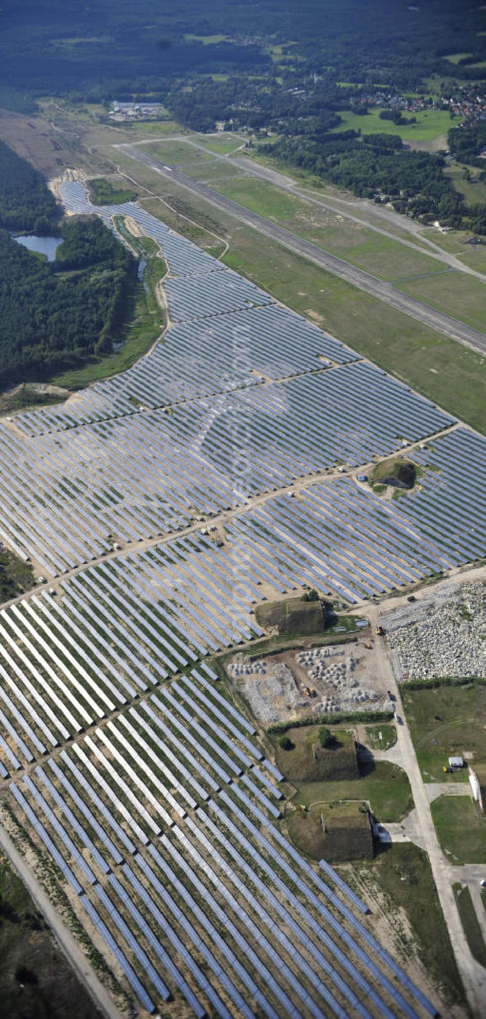 Aerial photograph Finow - Blick auf die fast fertig montierten Solarfelder des neuen Solarkraftwerk Finow Tower. Die solarhybrid AG errichtet gegenwärtig auf dem ehemaligen Militärflughafen ein Solarstrom-Kraftwerk. Auftraggeber ist die solarinvestra FinowTower GmbH & Co. KG, welche als Fondsgesellschaft durch die interstrom AG und die CH2 Contorhaus Hansestadt Hamburg AG gegründet wurde und das Solarstrom-Kraftwerk betreiben wird. Eigentümer der Immobilie ist die is solarinvestra FT Grundstücks GmbH & Co. KG, eine Tochter von interstrom, die eine Teilfläche des Flughafens von 77 Hektar von der Wirtschafts-Verkehrs-Zentrum GmbH (WZV) erworben hat. View of the almost fully assembled solar fields of the new solar power plant Finow Tower. The hybrid solar AG is currently building on the former military airport, a solar power plant.